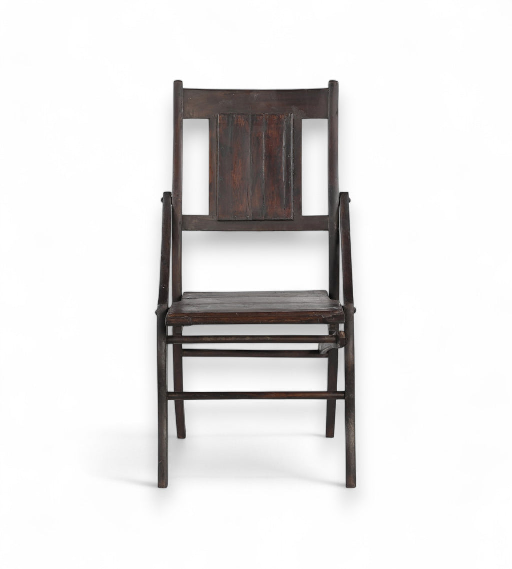 A vintage teak wood chair with a deep rich dark brown finish, featuring a gently curved backrest and seat.