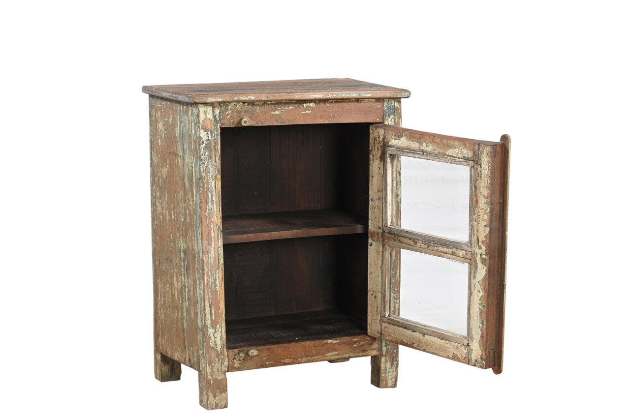 A vintage rustic teak wood side cabinet with a weathered frame, a glass door, and a metal pull ring.