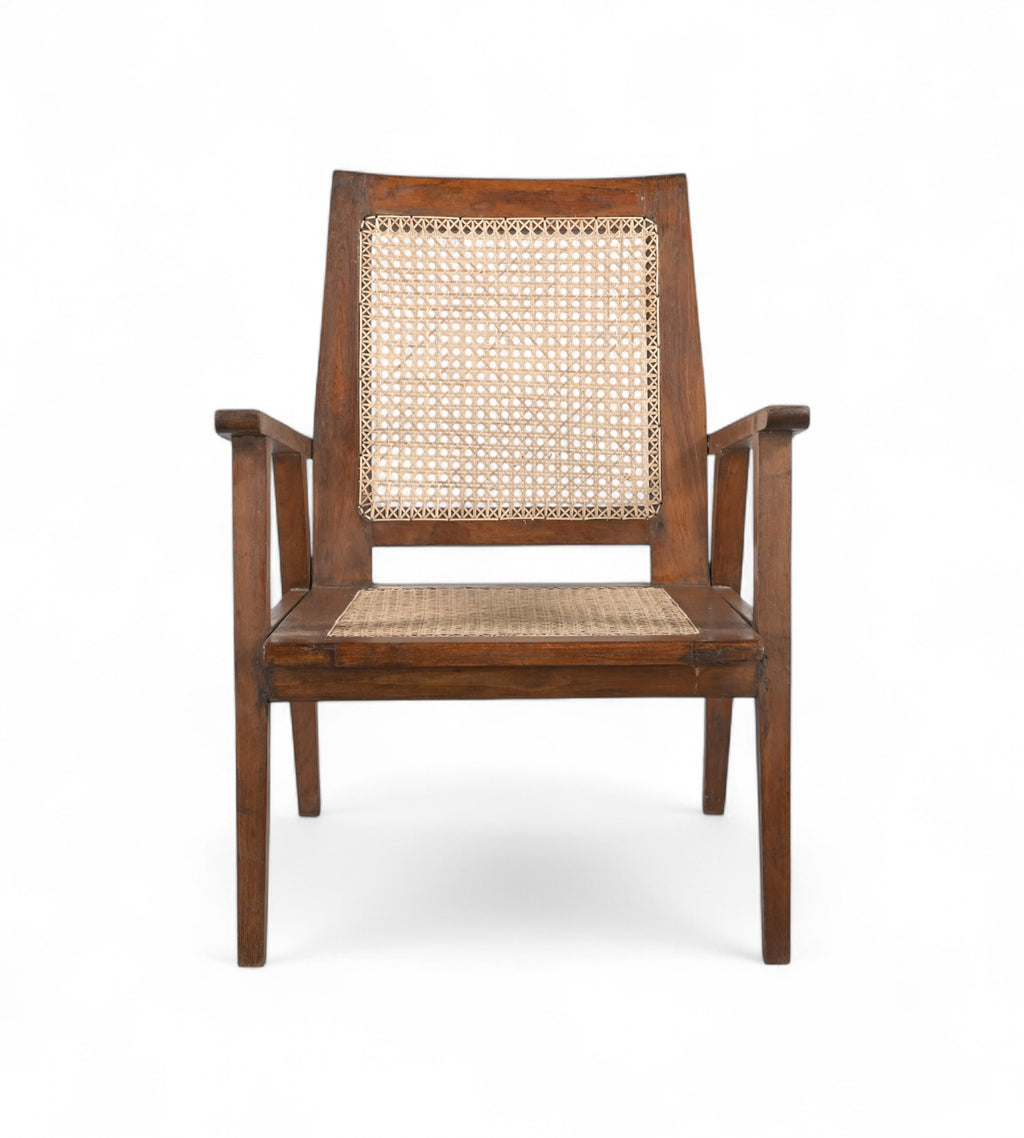 A vintage teak wood armchair with handwoven natural rattan seat and backrest, featuring sculptural arms and a low slung seat.